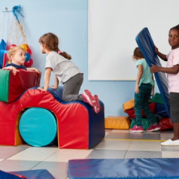 A group of young children playing with gym building blocks